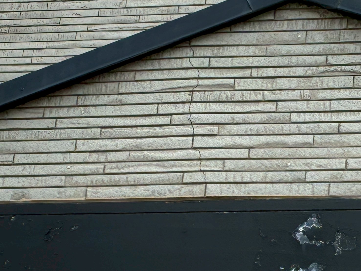 屋根の妻部分のサイディングにひびが入っている